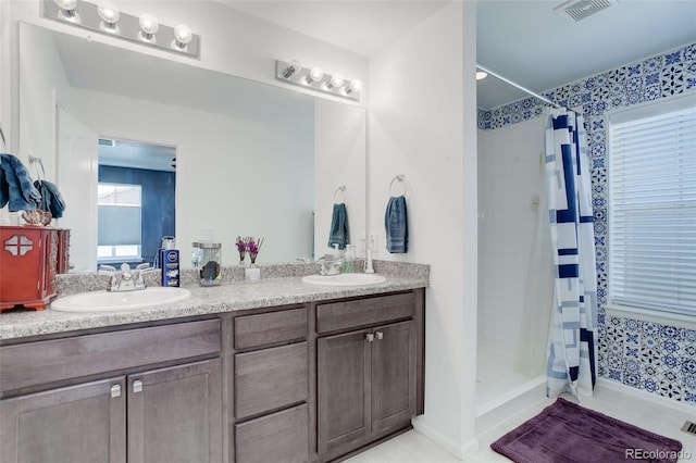 bathroom featuring tile patterned flooring, vanity, and walk in shower