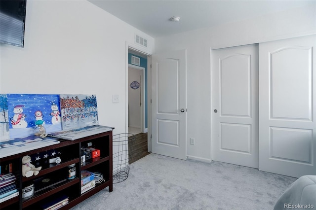 bedroom featuring light colored carpet and a closet