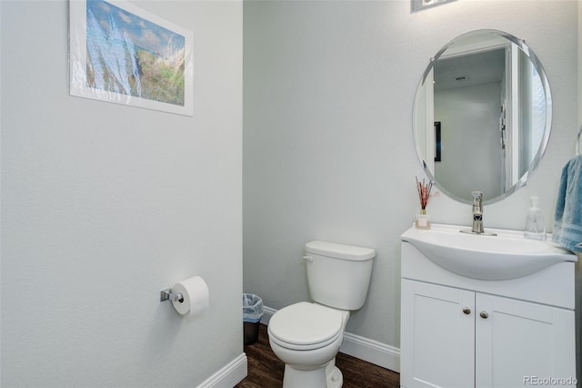 bathroom featuring vanity, wood-type flooring, and toilet