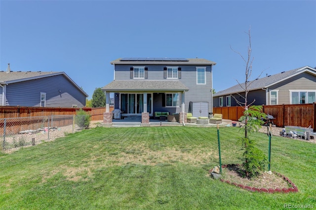 rear view of house with a lawn, outdoor lounge area, a patio, and solar panels