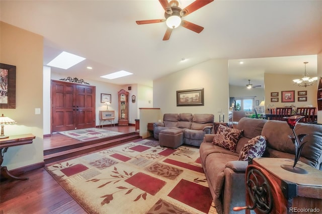 living room featuring recessed lighting, wood finished floors, vaulted ceiling with skylight, baseboards, and ceiling fan with notable chandelier