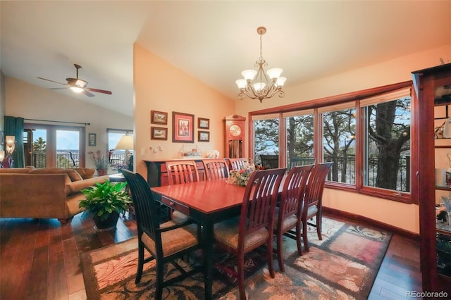 dining area featuring ceiling fan with notable chandelier, lofted ceiling, baseboards, and hardwood / wood-style flooring