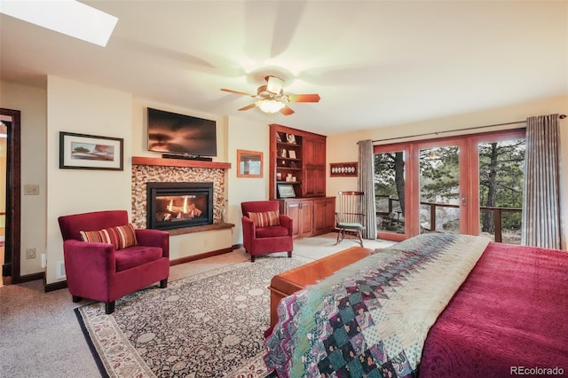 bedroom with access to exterior, baseboards, carpet flooring, and a glass covered fireplace