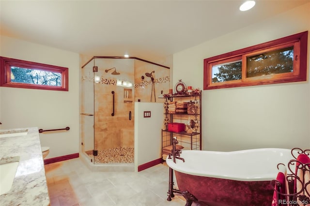 full bath with a stall shower, vanity, baseboards, and a soaking tub