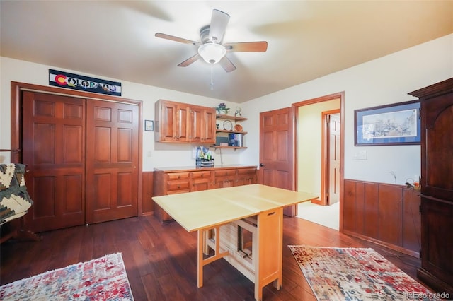 kitchen featuring a wainscoted wall, a ceiling fan, light countertops, dark wood-style floors, and open shelves