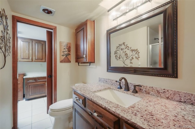 bathroom with toilet, vanity, a shower, and tile patterned floors