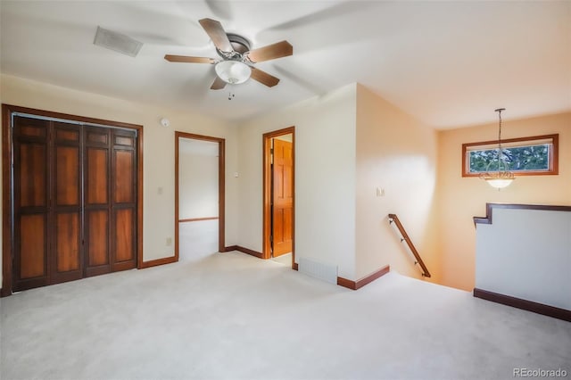 unfurnished bedroom featuring baseboards, visible vents, and light colored carpet