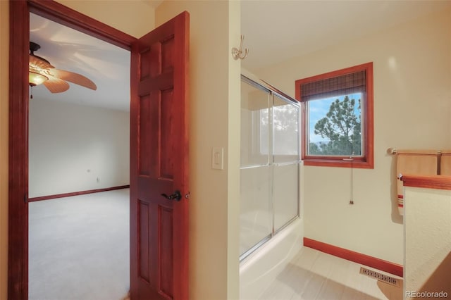 bathroom featuring ceiling fan, combined bath / shower with glass door, visible vents, and baseboards