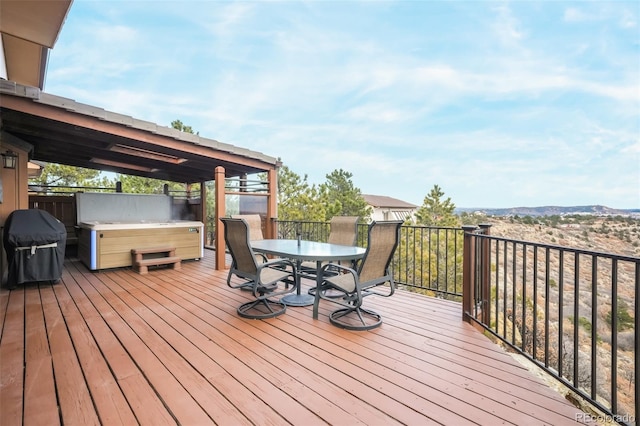 wooden terrace featuring outdoor dining area, a grill, and a hot tub