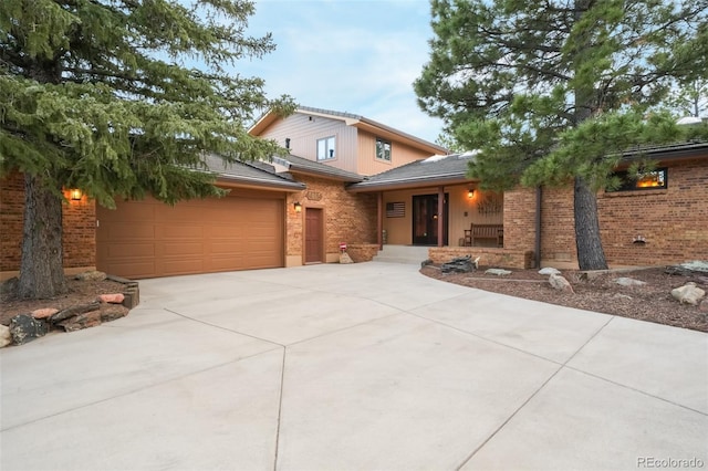 view of front of property with concrete driveway, brick siding, and covered porch