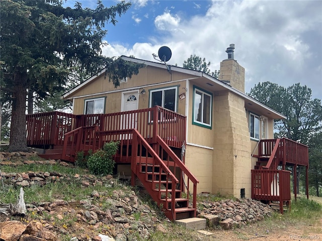95 Appleby St, Bailey, CO 80421 - view of front facade featuring concrete block siding, stairs, a chimney, and a deck