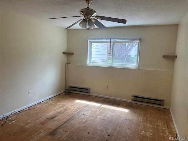 spare room with a baseboard heating unit, a ceiling fan, baseboards, and hardwood / wood-style floors