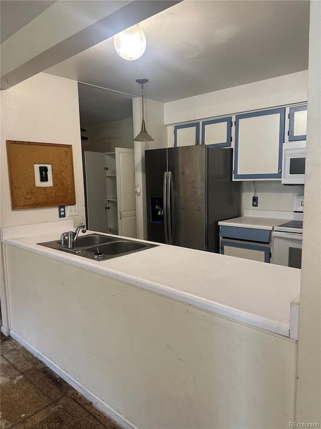 kitchen with light countertops, decorative light fixtures, a sink, and white appliances