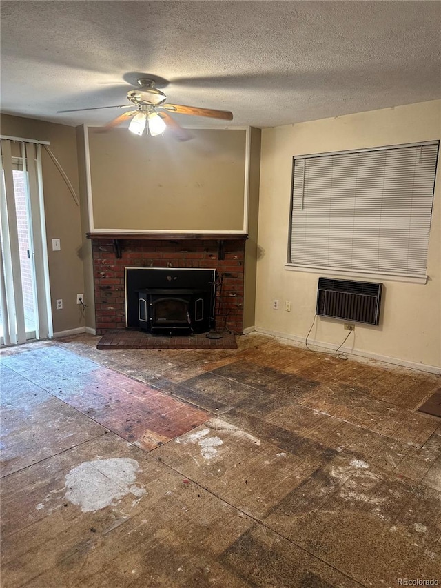 unfurnished living room with baseboards, a ceiling fan, a textured ceiling, and a wall mounted AC