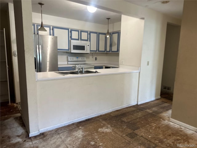 kitchen with a peninsula, pendant lighting, white appliances, and light countertops