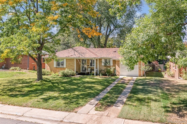 ranch-style home featuring driveway, an attached garage, covered porch, a front lawn, and brick siding