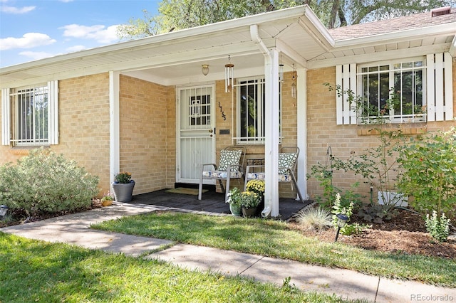 property entrance featuring brick siding and covered porch