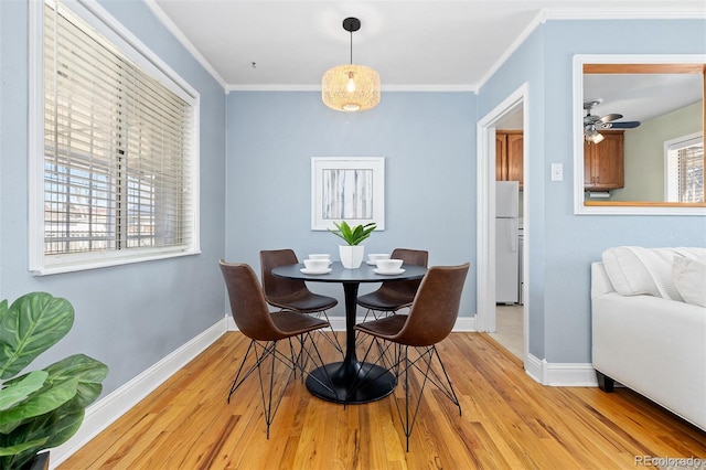 dining room with crown molding, baseboards, and wood finished floors