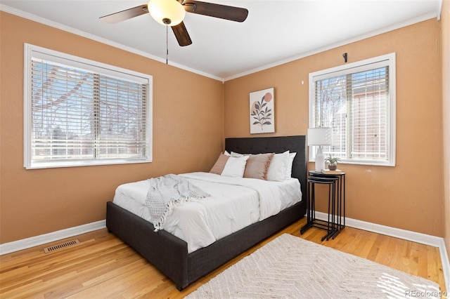 bedroom with multiple windows, visible vents, and crown molding