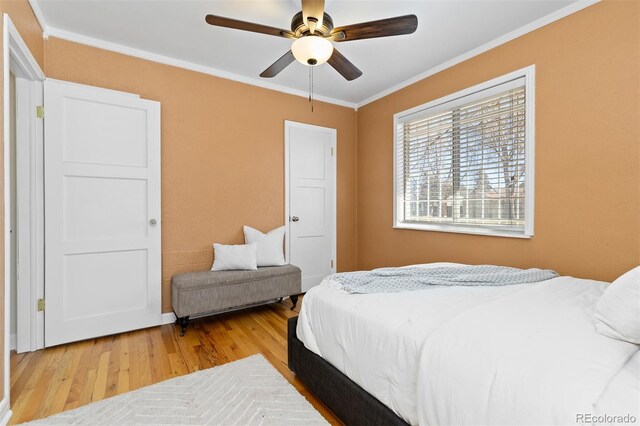 bedroom with ornamental molding, wood finished floors, and a ceiling fan