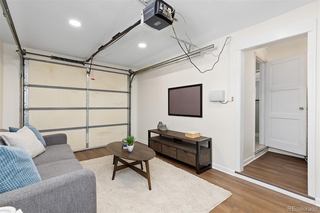 garage with a garage door opener, recessed lighting, and baseboards