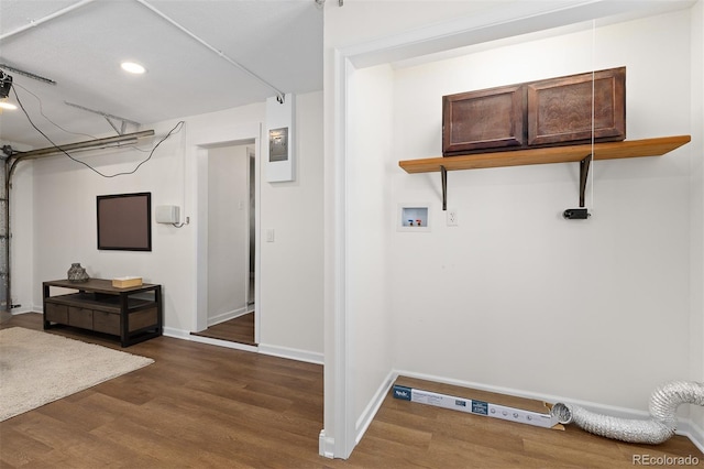 washroom featuring laundry area, baseboards, washer hookup, and dark wood-type flooring