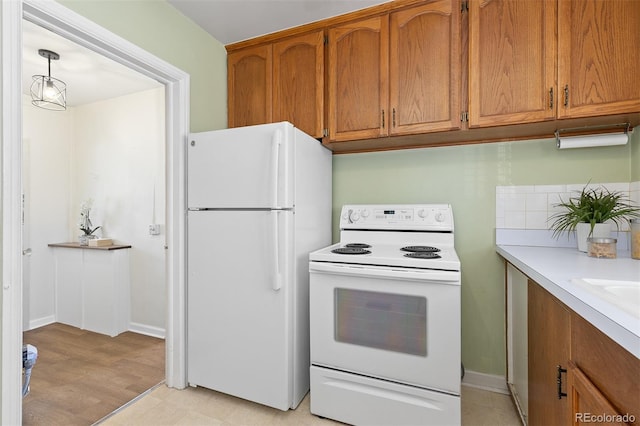 kitchen featuring white appliances, brown cabinetry, and light countertops