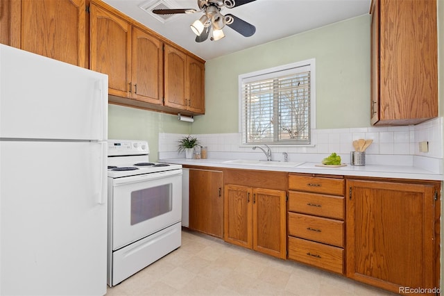 kitchen featuring white appliances, light countertops, a sink, and brown cabinetry