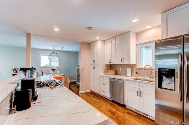 kitchen featuring pendant lighting, a healthy amount of sunlight, sink, and stainless steel appliances