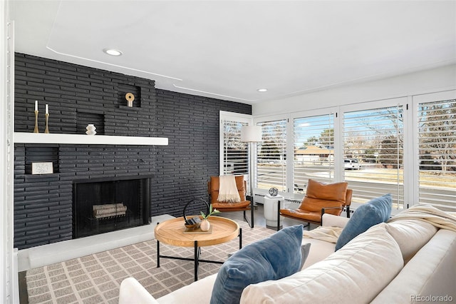 living room featuring a brick fireplace, brick wall, and recessed lighting