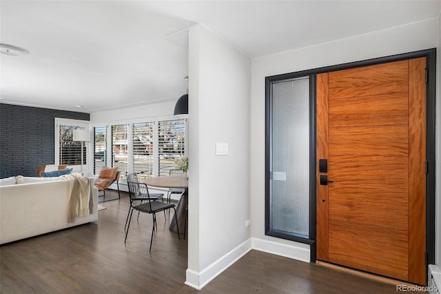 foyer featuring baseboards and wood finished floors