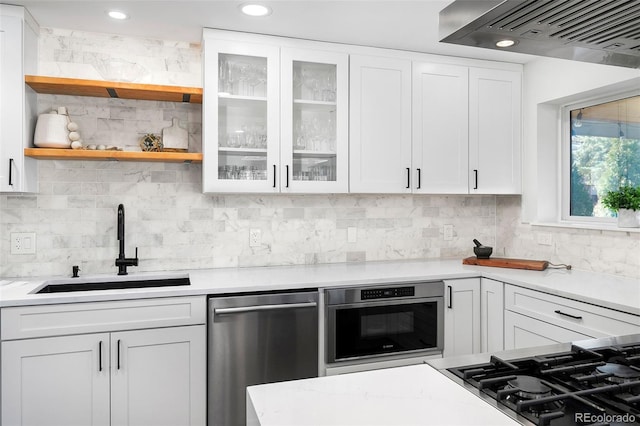 kitchen with white cabinetry, appliances with stainless steel finishes, extractor fan, and a sink