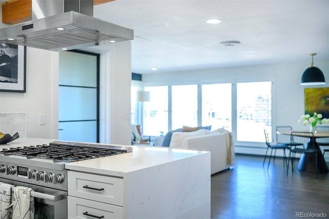 kitchen featuring high end stainless steel range oven, plenty of natural light, white cabinets, and island exhaust hood