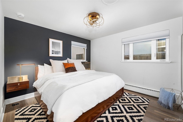 bedroom featuring a baseboard radiator and wood finished floors