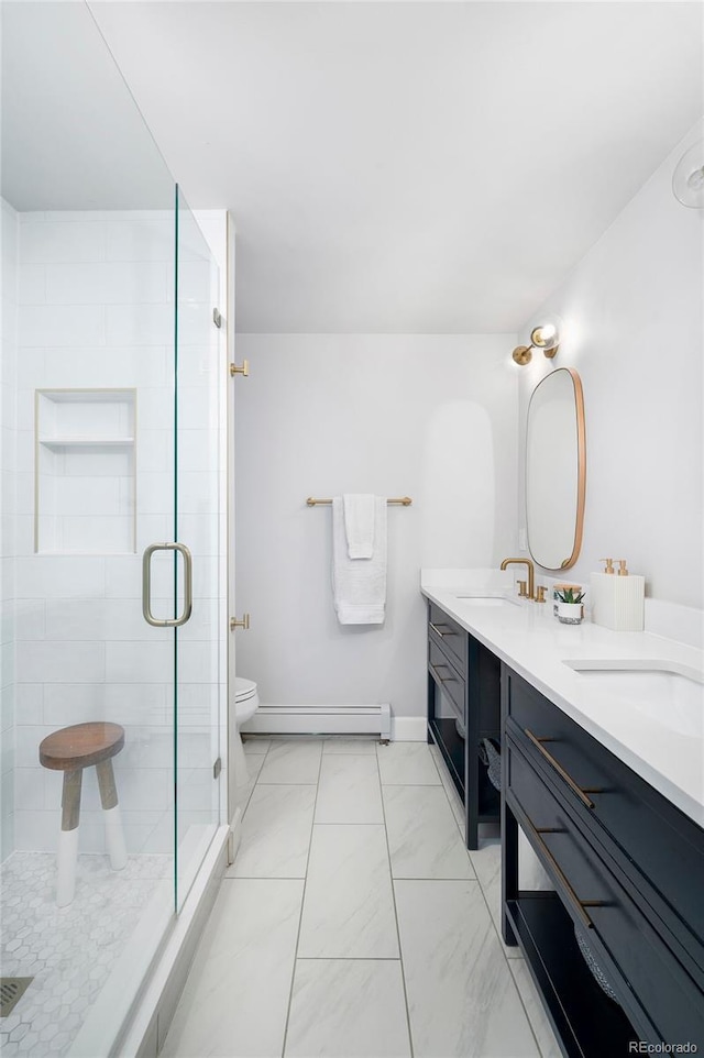 full bath featuring double vanity, a stall shower, toilet, a baseboard radiator, and a sink