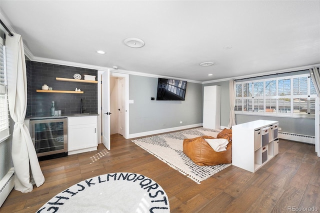 living room featuring indoor wet bar, a baseboard radiator, wood finished floors, beverage cooler, and baseboards