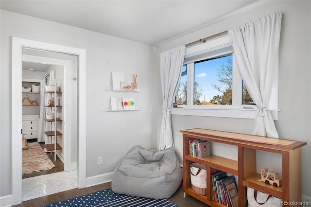 sitting room with baseboards and wood finished floors