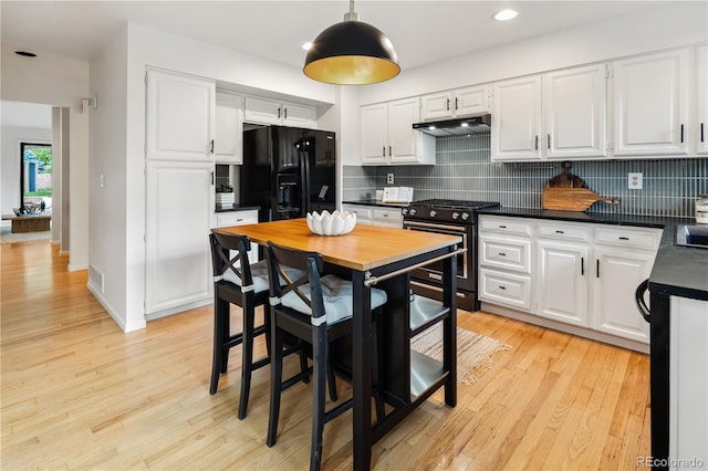 9400 E Iliff Ave Unit 292, Denver, CO 80231 - kitchen featuring gas stove, black fridge with ice dispenser, under cabinet range hood, backsplash, and recessed lighting