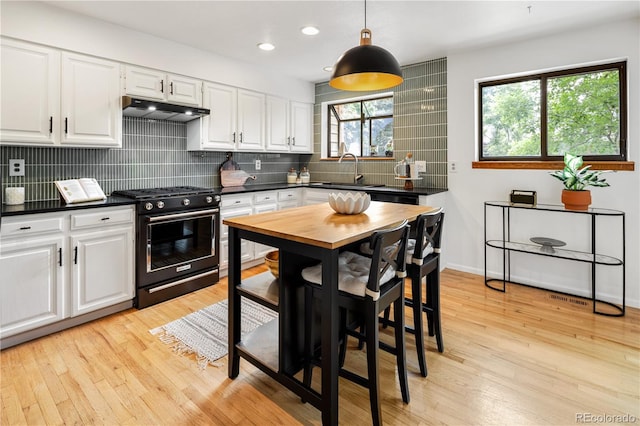 9400 E Iliff Ave Unit 292, Denver, CO 80231 - kitchen with black range with gas stovetop, under cabinet range hood, dark countertops, white cabinetry, and recessed lighting