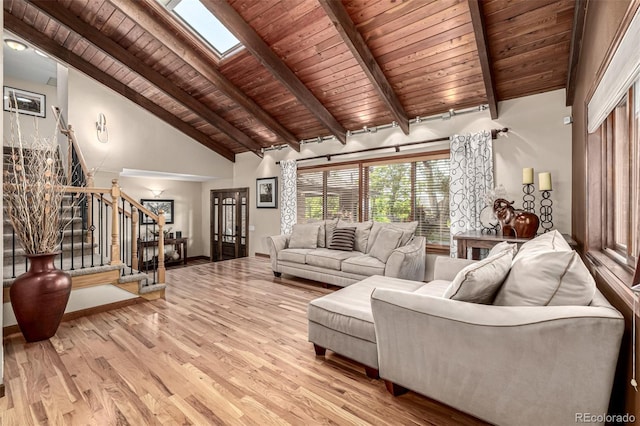 6740 S Windermere St, Littleton, CO 80120 - living room with wooden ceiling with exposed beams, stairway, light wood-style floors, a skylight, and baseboards