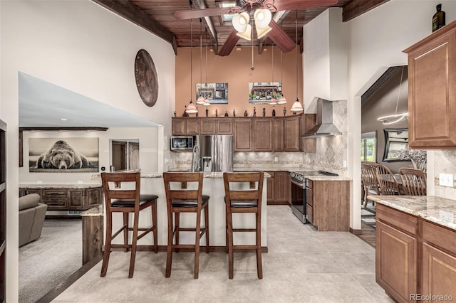 6740 S Windermere St, Littleton, CO 80120 - kitchen with stainless steel appliances, wall chimney range hood, a towering ceiling, wooden ceiling with exposed beams, and ceiling fan