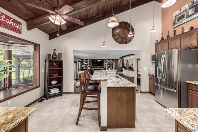 6740 S Windermere St, Littleton, CO 80120 - kitchen with stainless steel fridge, a sink, wood ceiling with exposed beams, a ceiling fan, and light stone counters