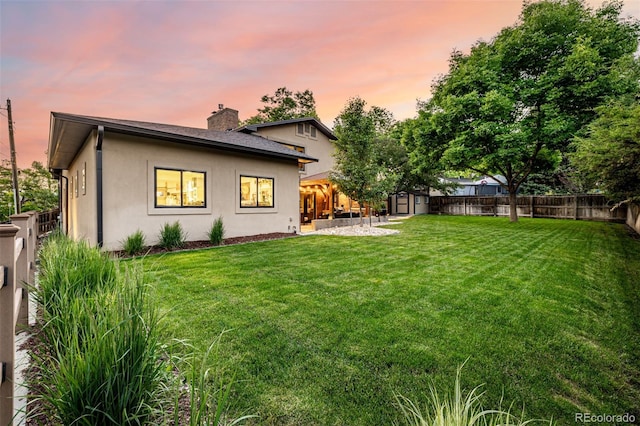 6740 S Windermere St, Littleton, CO 80120 - back of property at dusk with a chimney and stucco siding