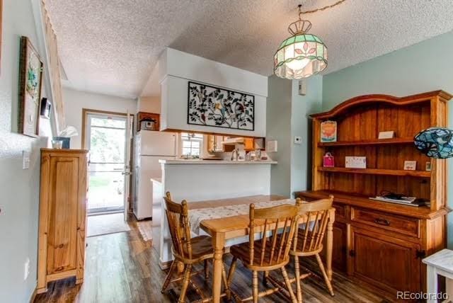dining space featuring a textured ceiling and wood finished floors
