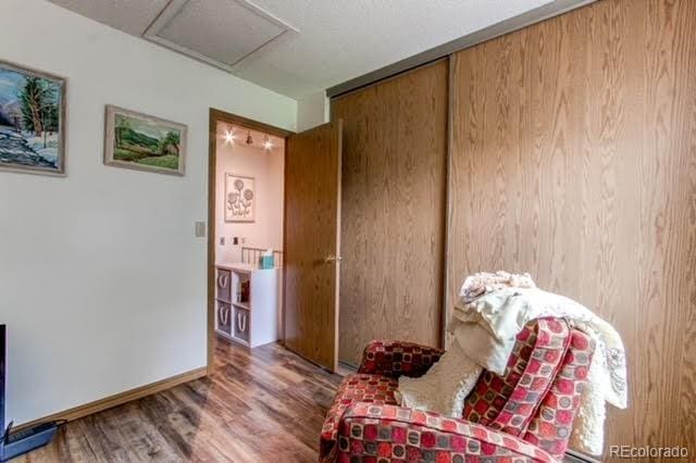 sitting room featuring attic access, baseboards, and wood finished floors