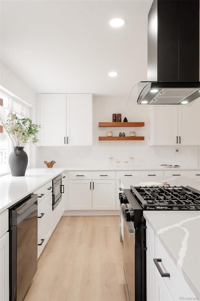 kitchen with light wood finished floors, dishwashing machine, range hood, white cabinetry, and stainless steel range with gas stovetop