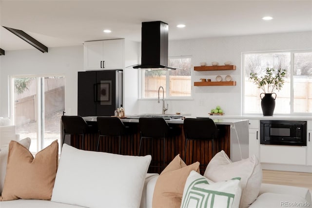 kitchen with black microwave, white cabinetry, light countertops, smart refrigerator, and island exhaust hood