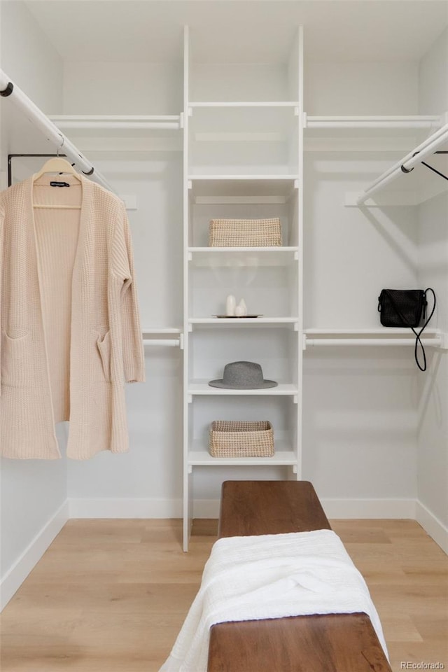 walk in closet with wood finished floors