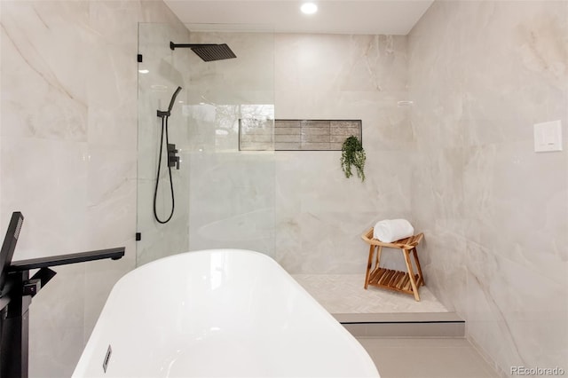 full bathroom featuring a freestanding bath, a walk in shower, and tile walls