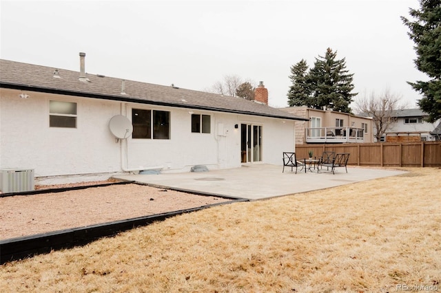 back of property featuring a chimney, fence, a patio area, central AC, and stucco siding